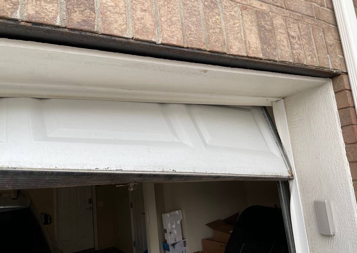 Garage door top panel and weather seal reset flush against the header