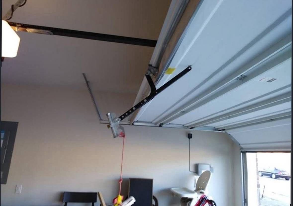 Close look at a garage door panel edge fitted flush against brick trim during a repair