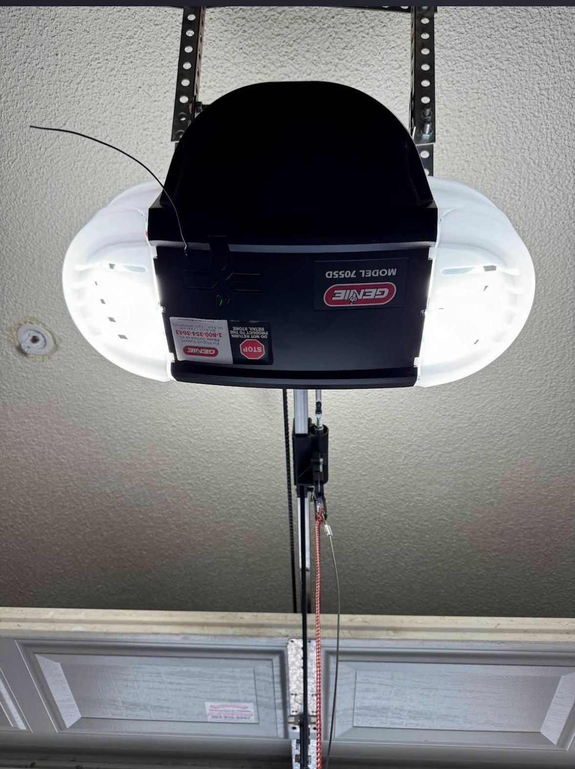 Genie garage door opener installed and running against a stucco ceiling